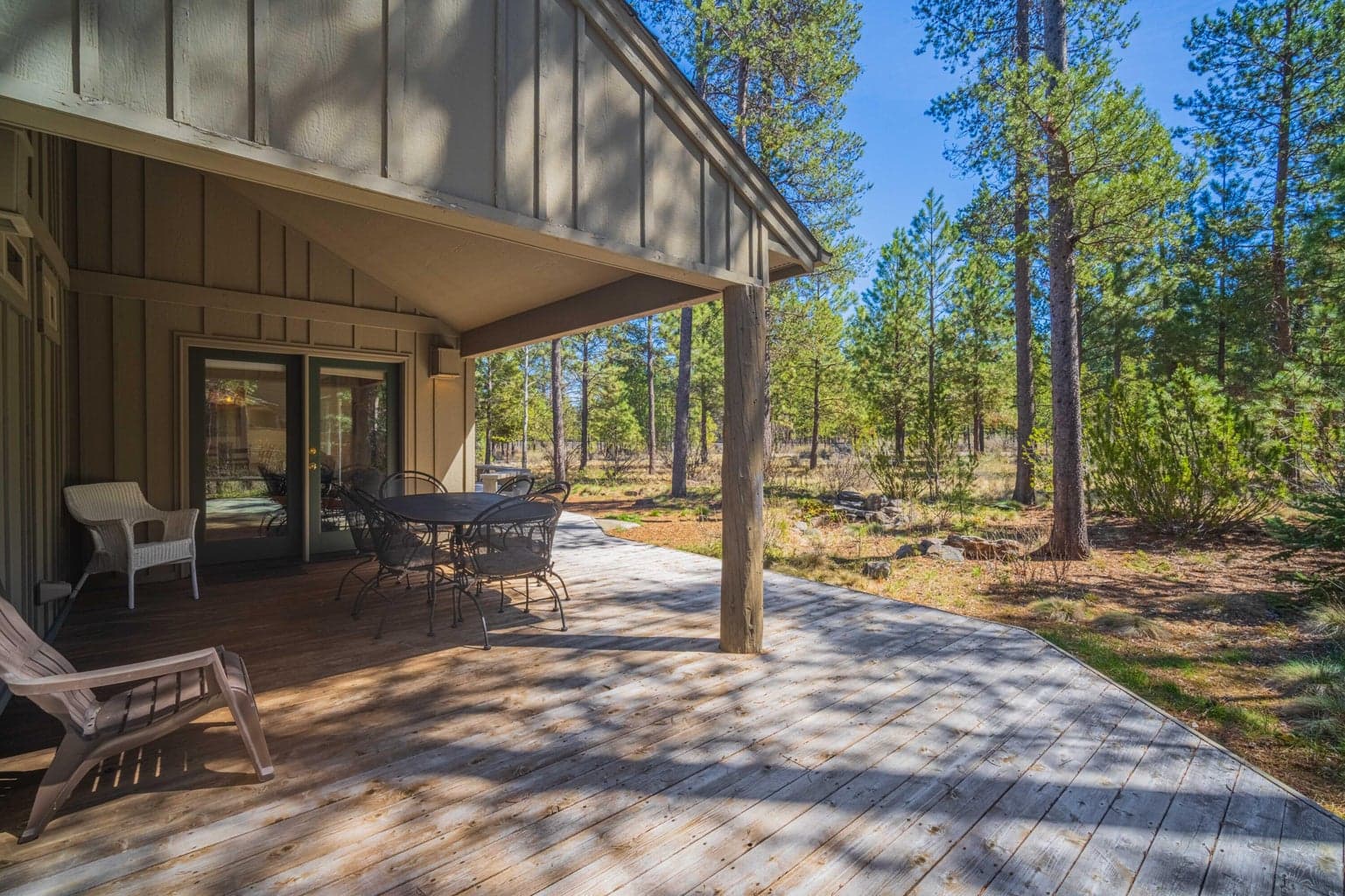 Spacious back deck with covered and open seating areas, ideal for outdoor living in Sunriver.