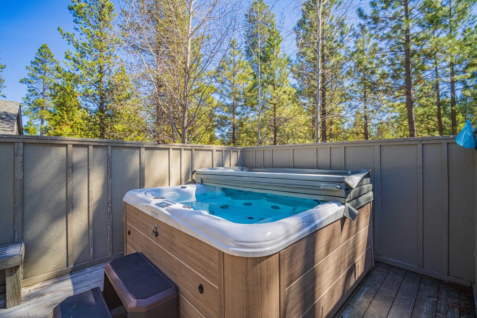 Private hot tub area on the deck, screened for comfort and surrounded by the Sunriver pine setting.
