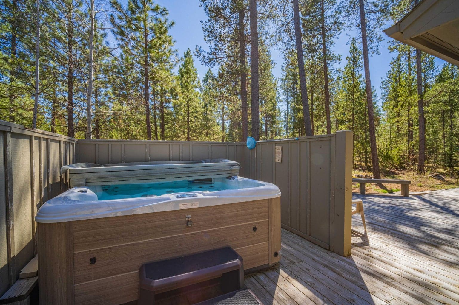 Hot tub and deck area with nearby seating, adding year-round relaxation to this Sunriver resort home.