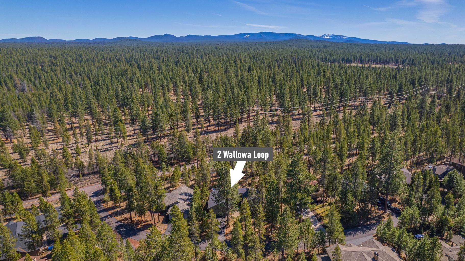 Final aerial view of 2 Wallowa Loop in Sunriver, Oregon, with the surrounding forested resort community and Cascade Mountain backdrop.