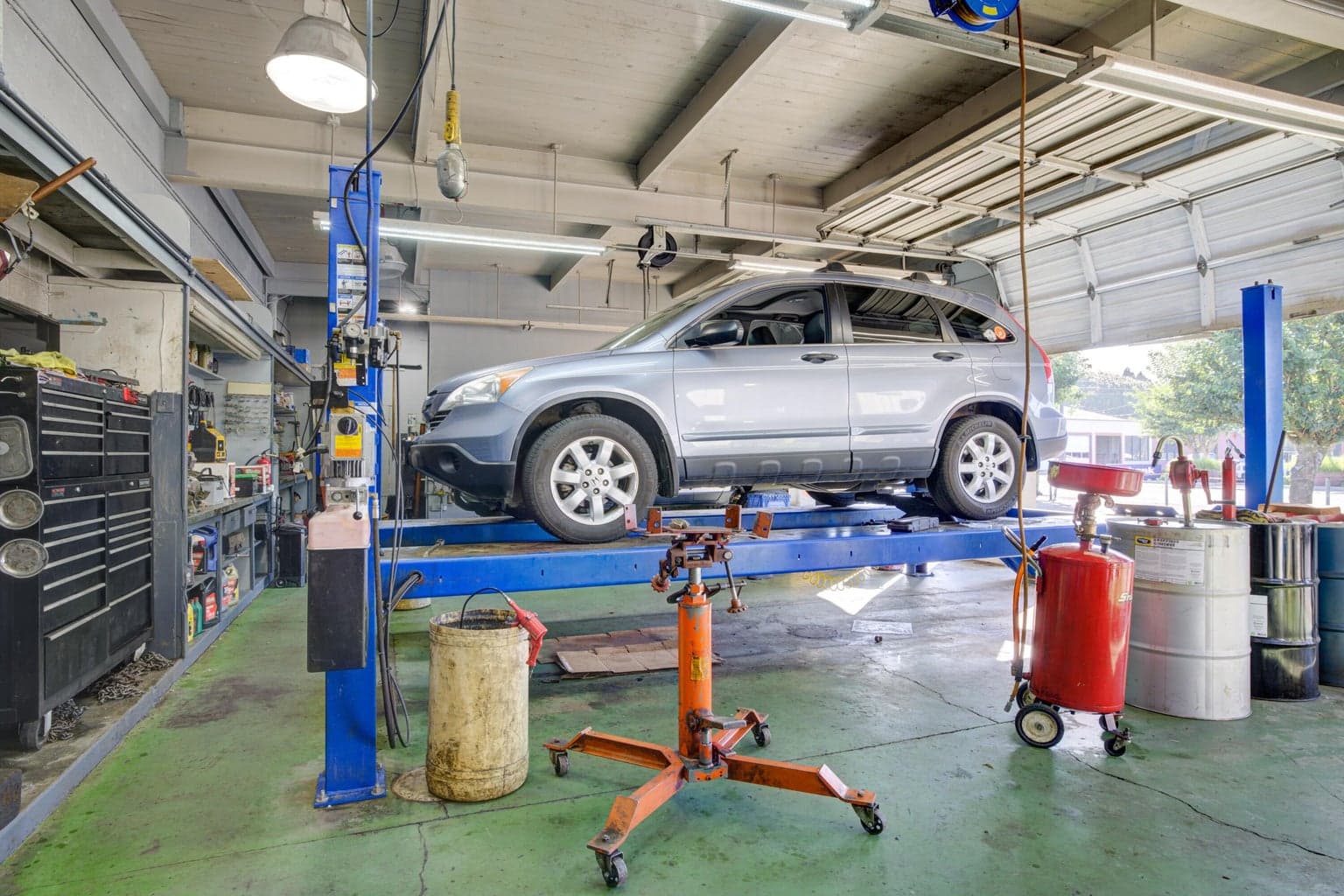 Highlights the functional workspace with two professional vehicle lifts.