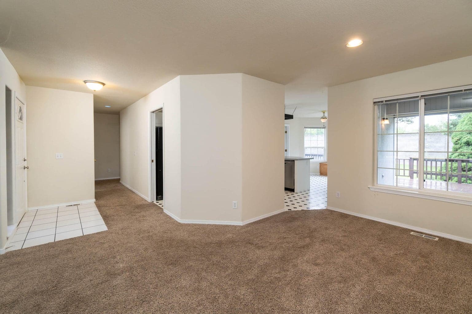 Living room with hallway to the 3-bedrooms and right to the kitchen.