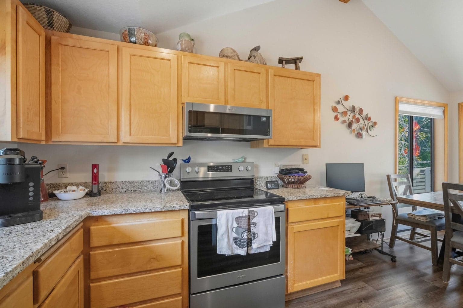 Kitchen with newer countertops, stainless appliances, and warm wood cabinetry.