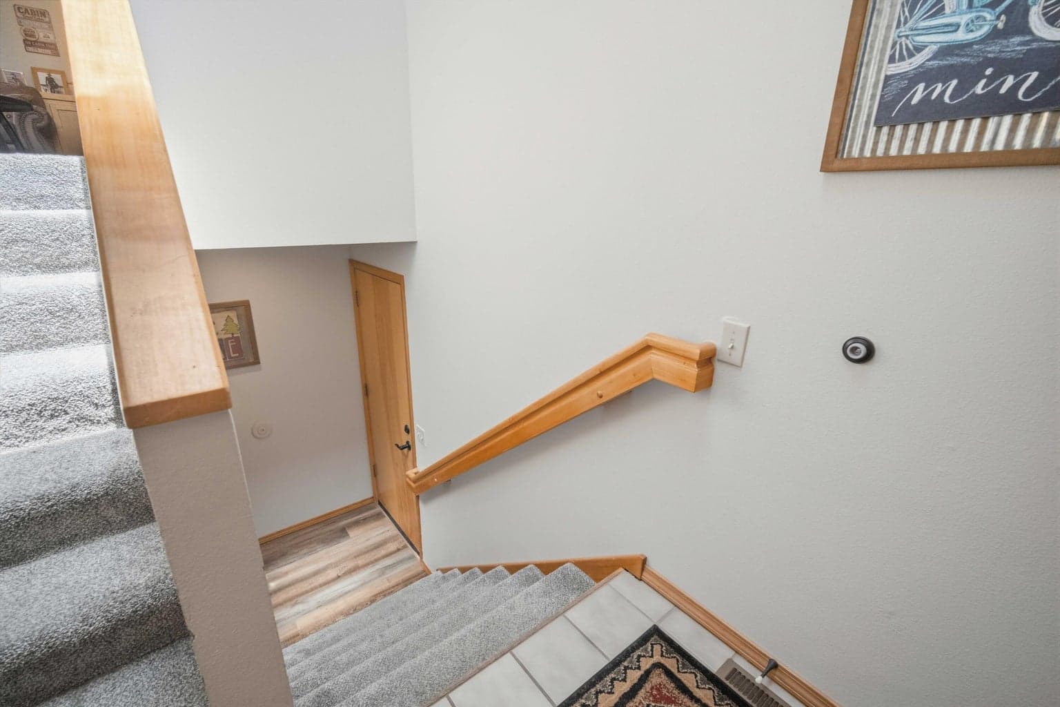 Split-level stair landing connecting the upper living spaces to the lower bedrooms and laundry.
