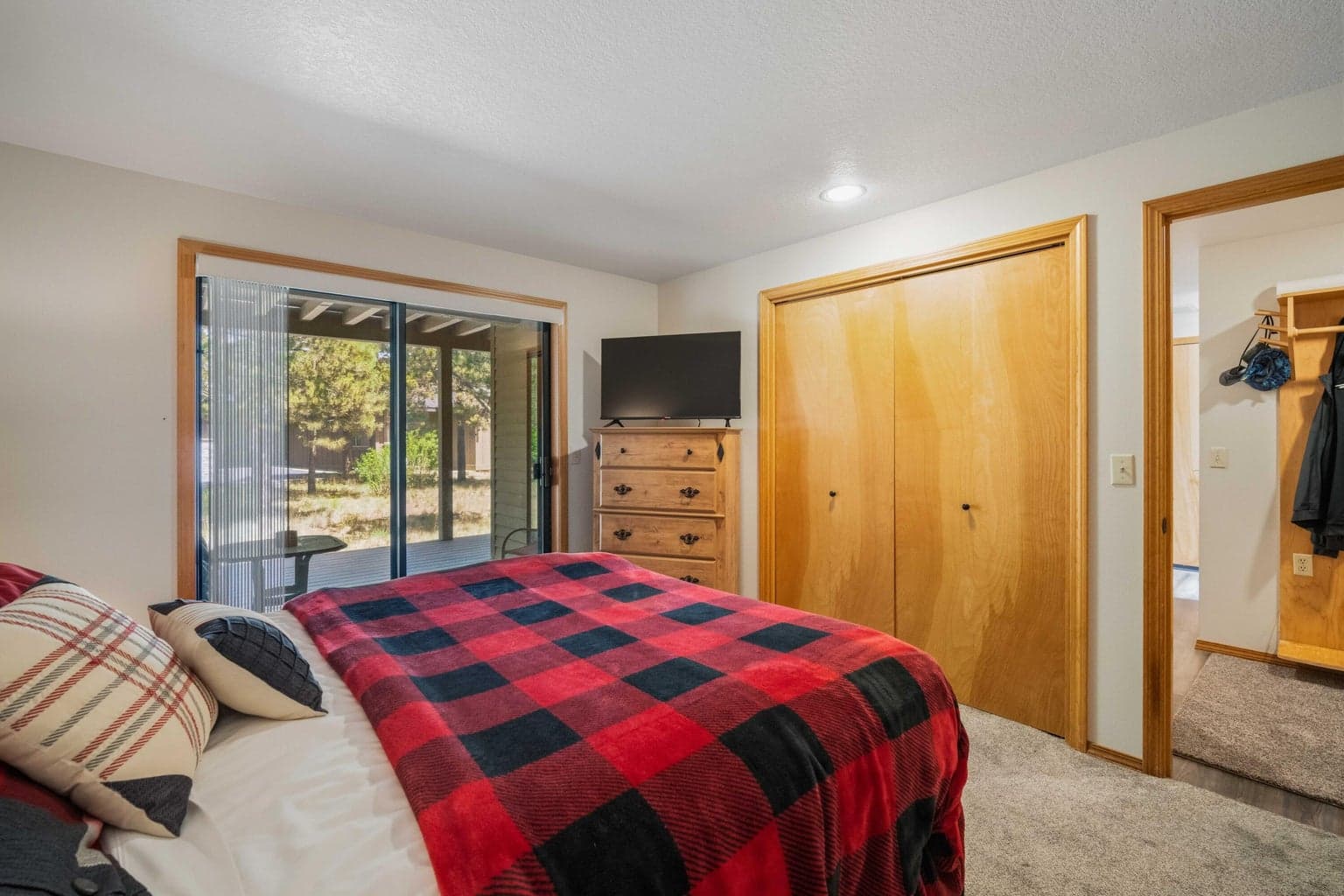 Lower guest bedroom with closet storage and access toward the lower-level hallway.