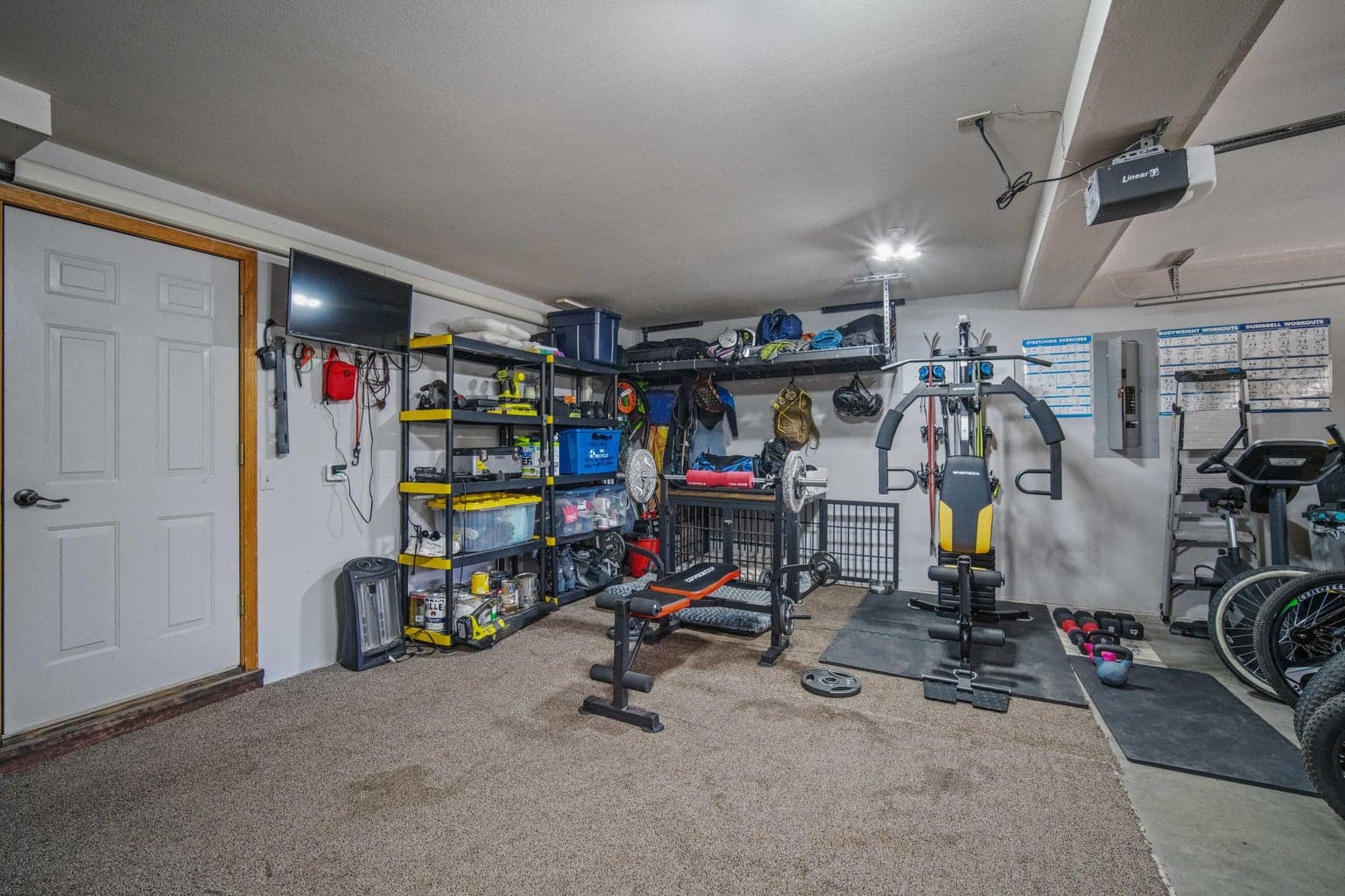 Attached garage configured with fitness space, storage, and recreation gear organization.