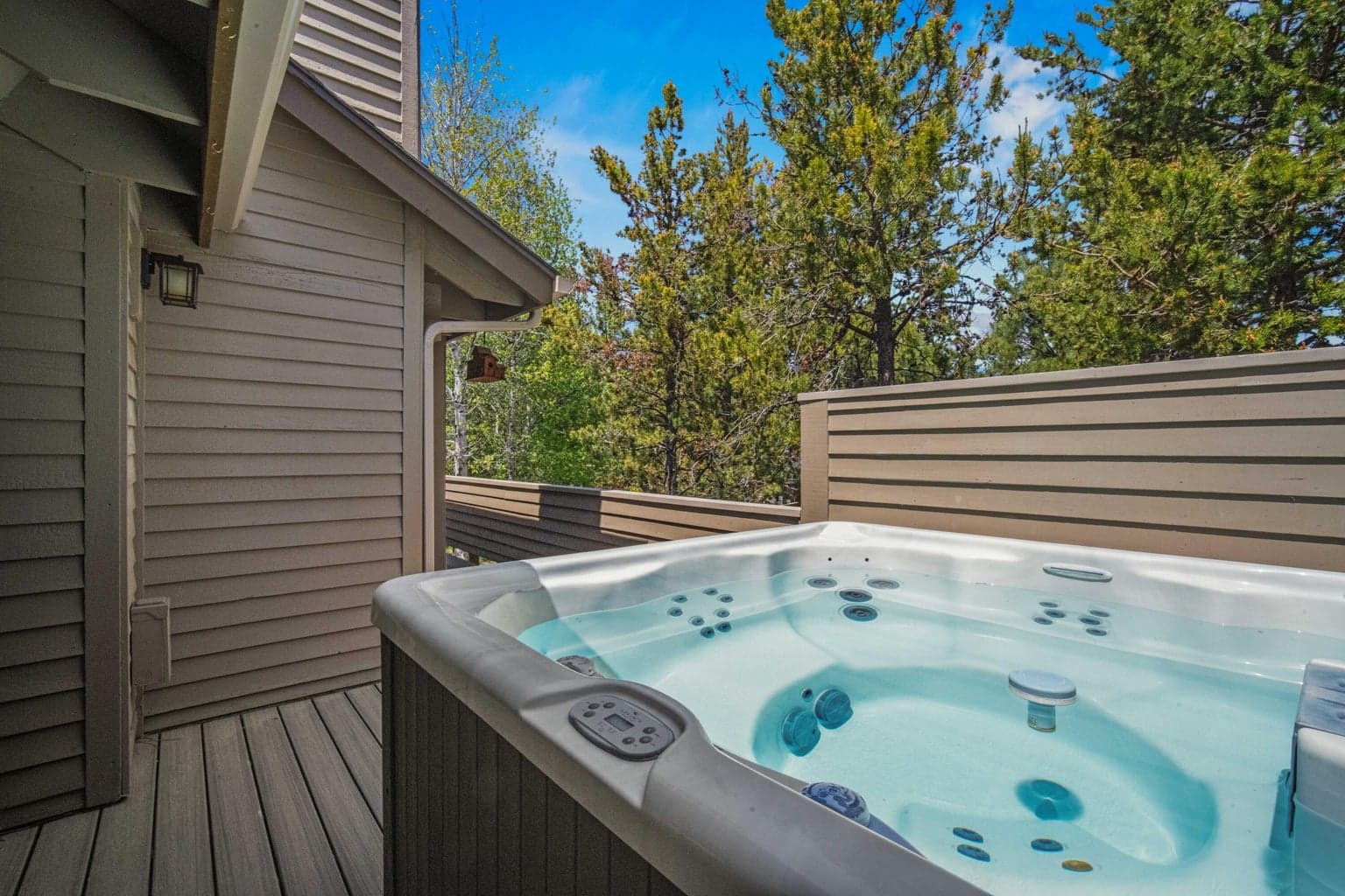 Hot tub area positioned for privacy and a relaxing Sunriver retreat feel.