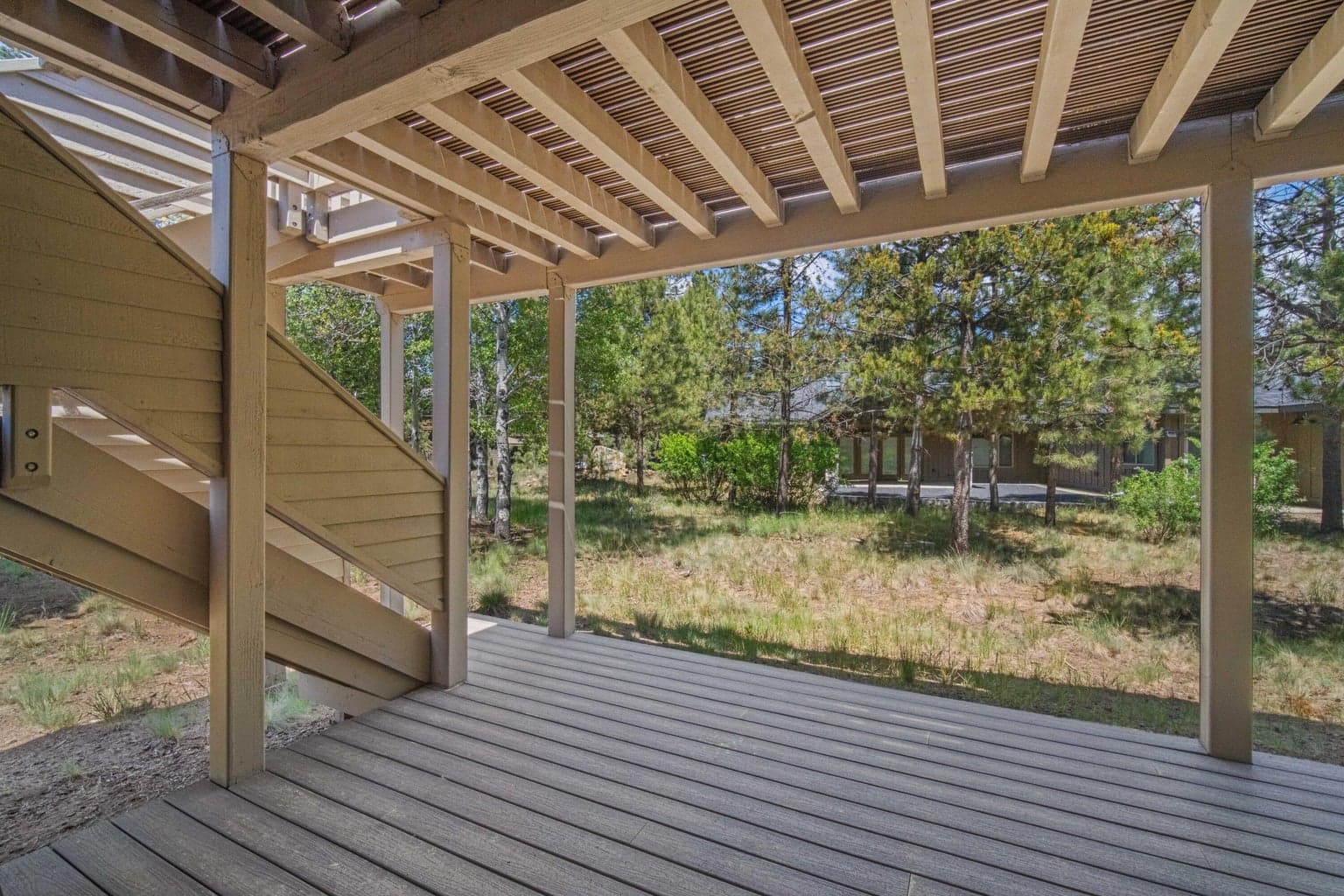 Lower covered deck looks out to the lightly treed natural Sunriver setting.
