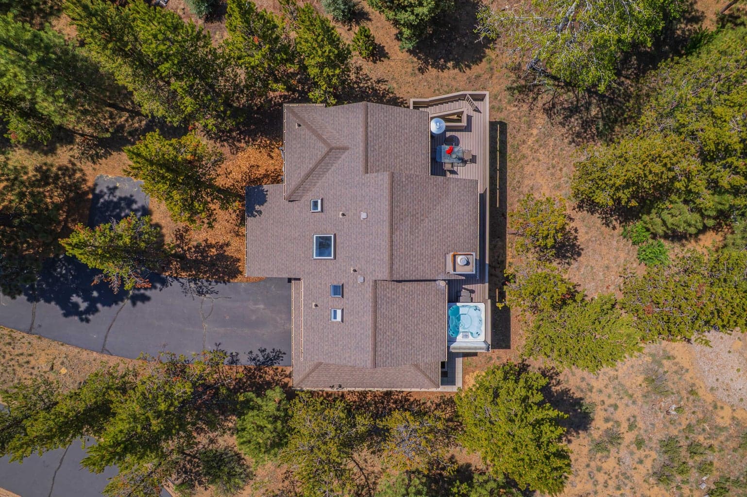 Aerial view showing roofline, skylights, decks, hot tub, and driveway placement.