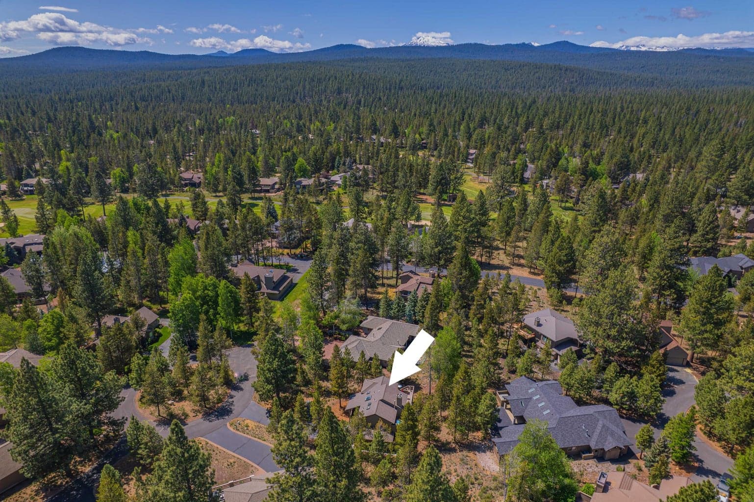 Aerial perspective over Sunriver, showing the forested setting and nearby golf course landscape.