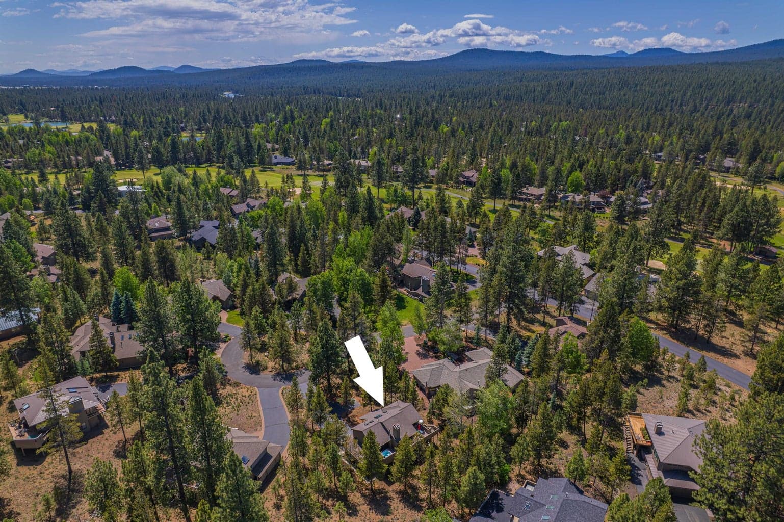 Elevated view of the Sunriver resort community with golf, trees, and mountain backdrop.