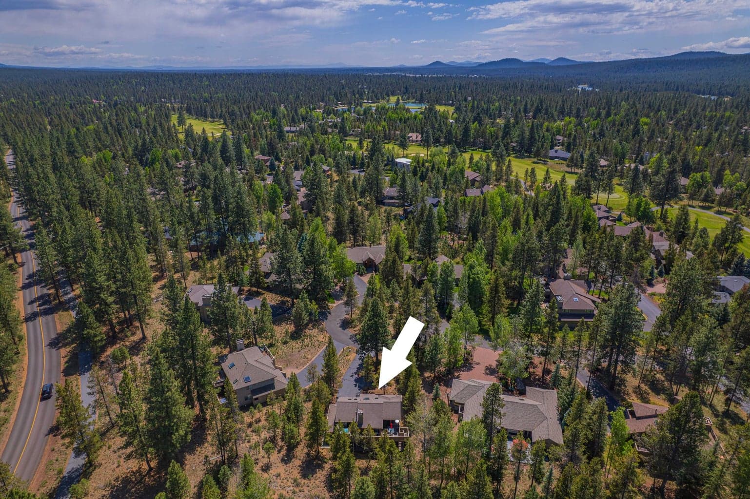 Broad aerial view showing Sunriver’s Central Oregon forest and Cascade mountain setting.