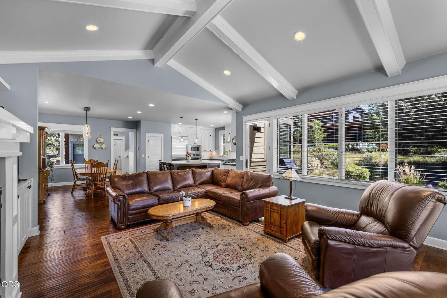Open-concept great room flows easily to the kitchen and dining areas, with warm wood floors, large windows, and inviting everyday comfort.