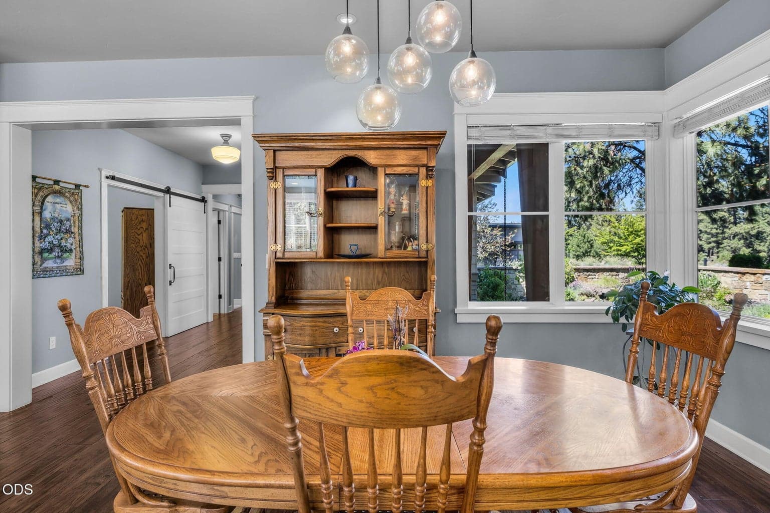 Bright dining area surrounded by windows and warm wood floors, offering an easy connection between kitchen, great room, and outdoor living.