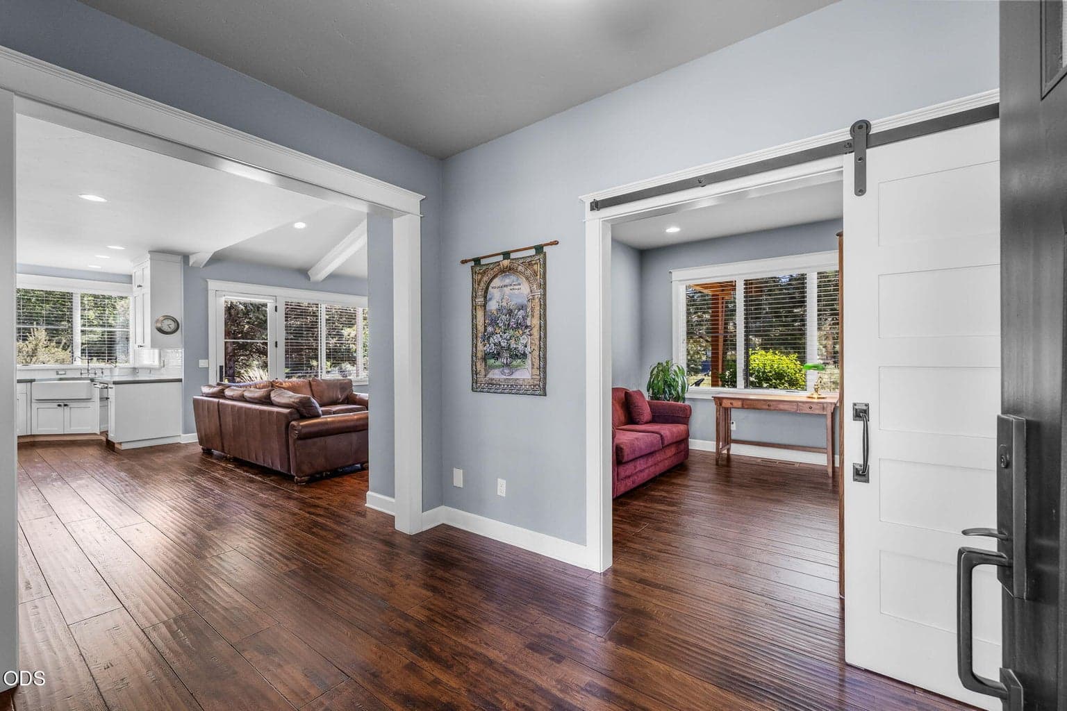 Main-level office with sliding barn door, rich wood flooring, and a convenient location just off the entry and main living areas.