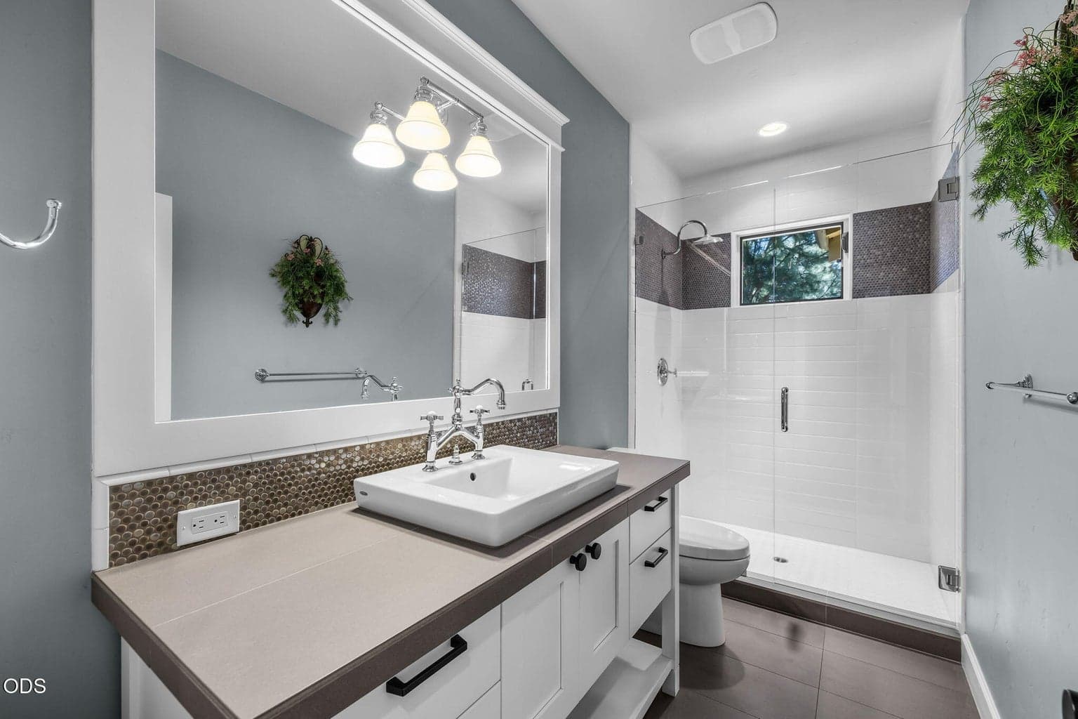 Stylish main-level full bath with walk-in shower, crisp white cabinetry, tile accents, and polished fixtures.
