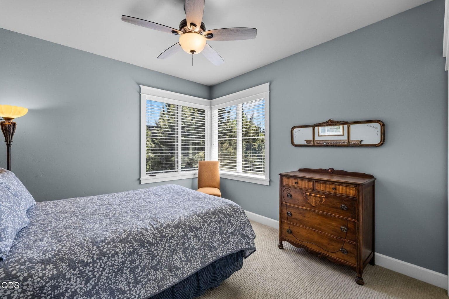 Comfortable upper-level guest bedroom with soft natural light, neutral finishes, and treetop outlooks.