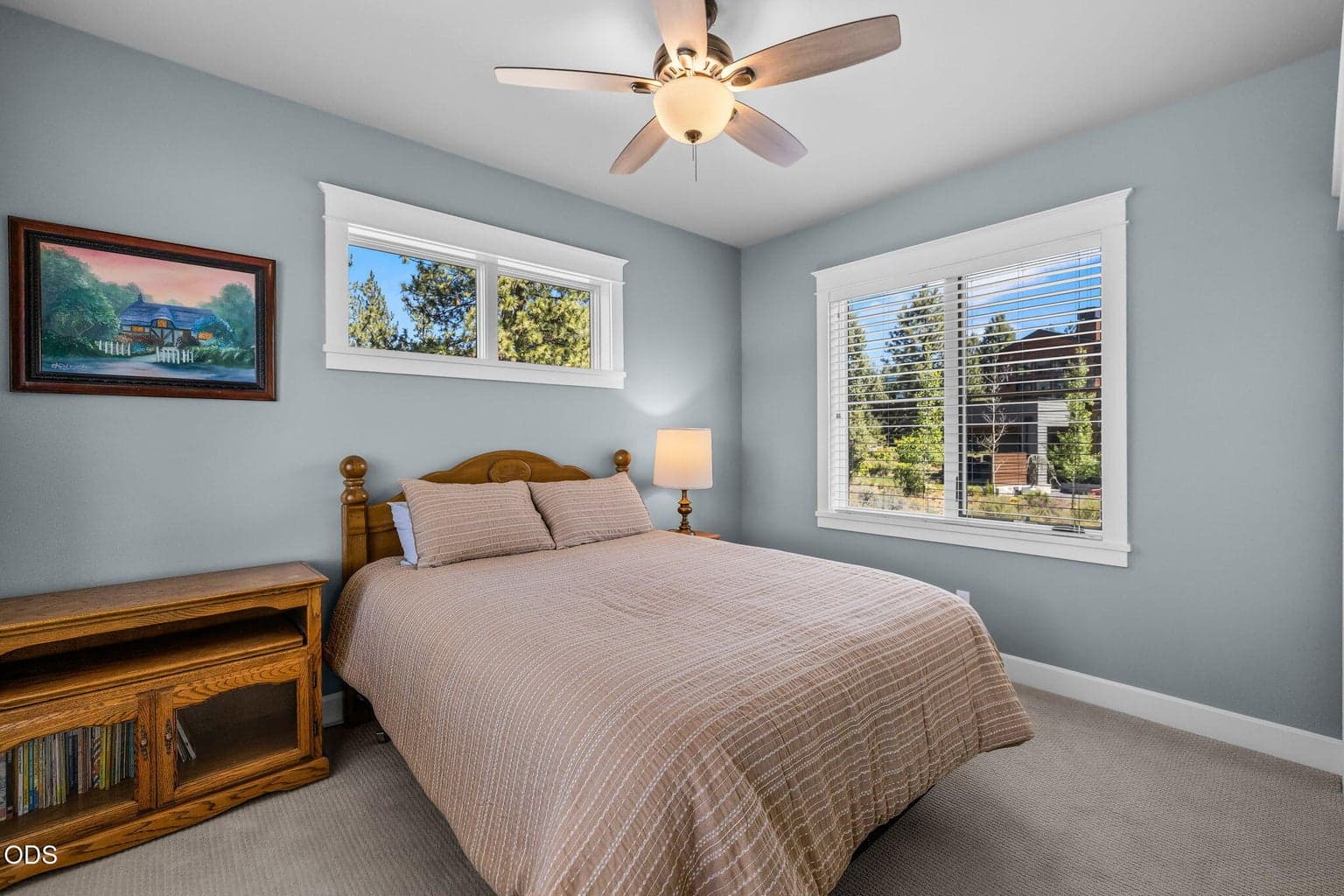 Bright guest bedroom with generous closet storage, ceiling fan, and elevated views toward the surrounding landscape.
