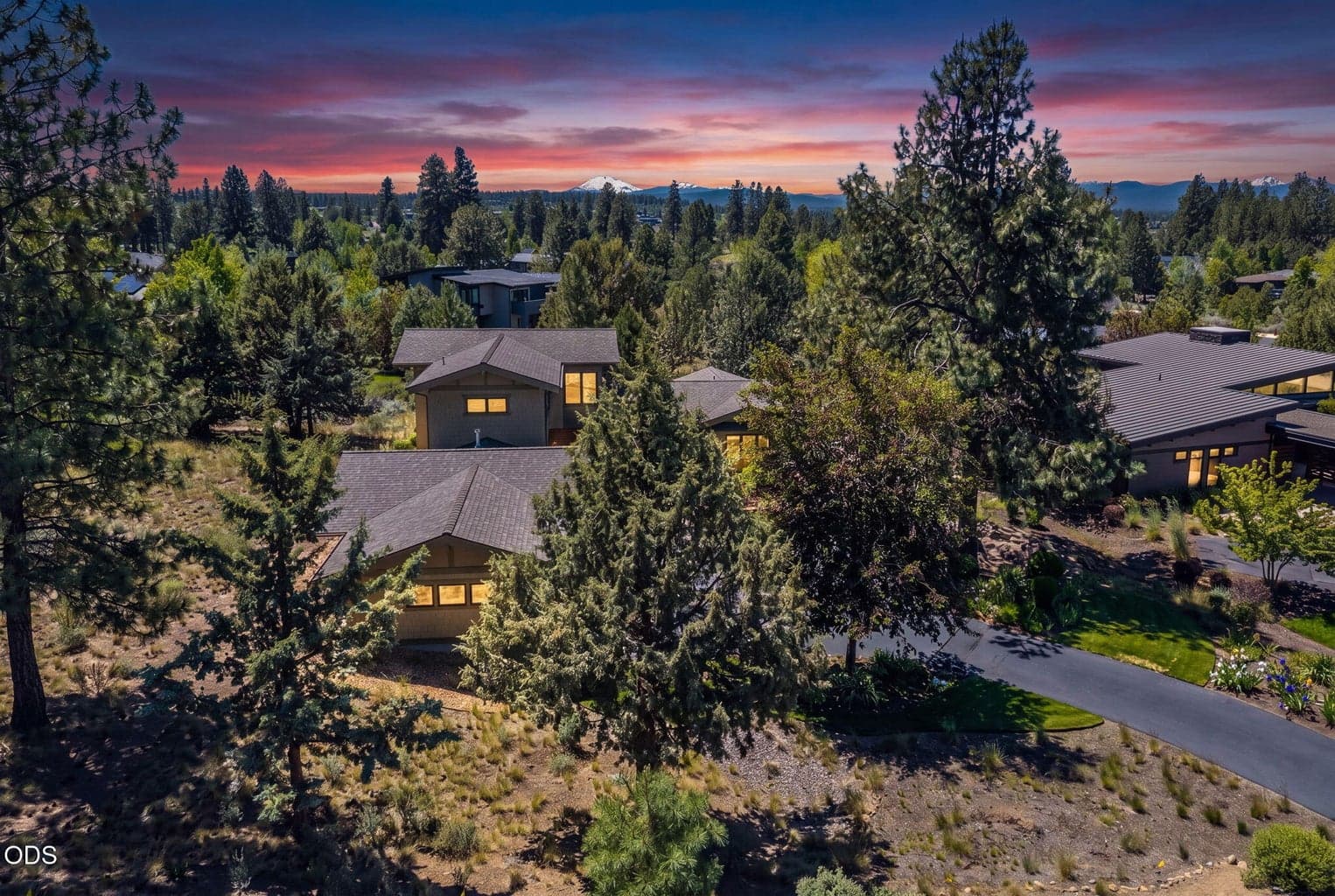 Dramatic twilight approach showcases the home’s beautiful architecture, extensive landscaping, and generous driveway leading to the three-car garage.