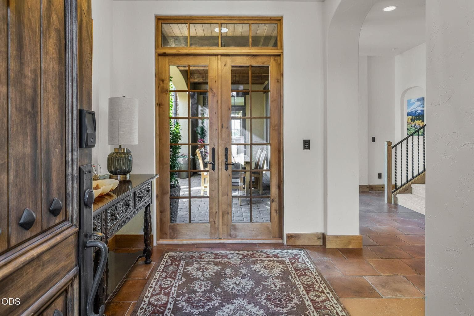 A gracious foyer sets the tone, drawing your eye to the tranquil inner courtyard beyond through one of many sets of French doors