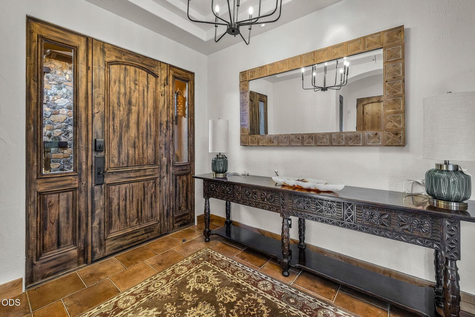 A solid wood front door and coffered ceilings add warmth, character, and timeless elegance