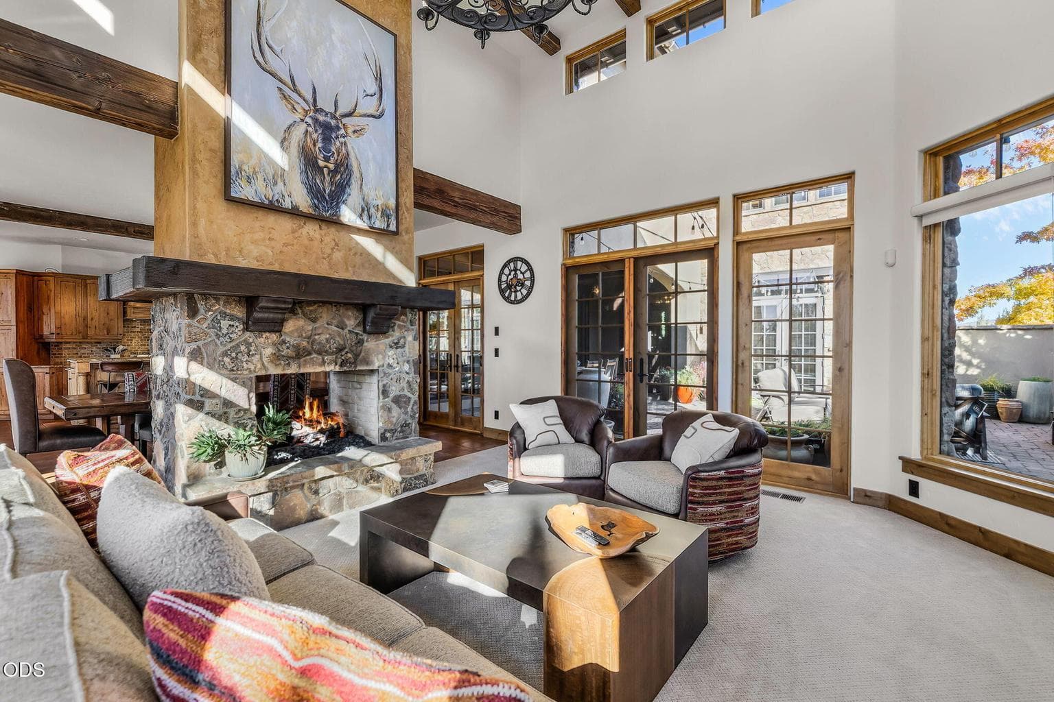 Double-sided stone fireplace in the great room offers dramatic scale and warmth. Oversized solid wood doors throughout. Rich wood-framed windows add warmth, character, and timeless craftsmanship throughout the home.