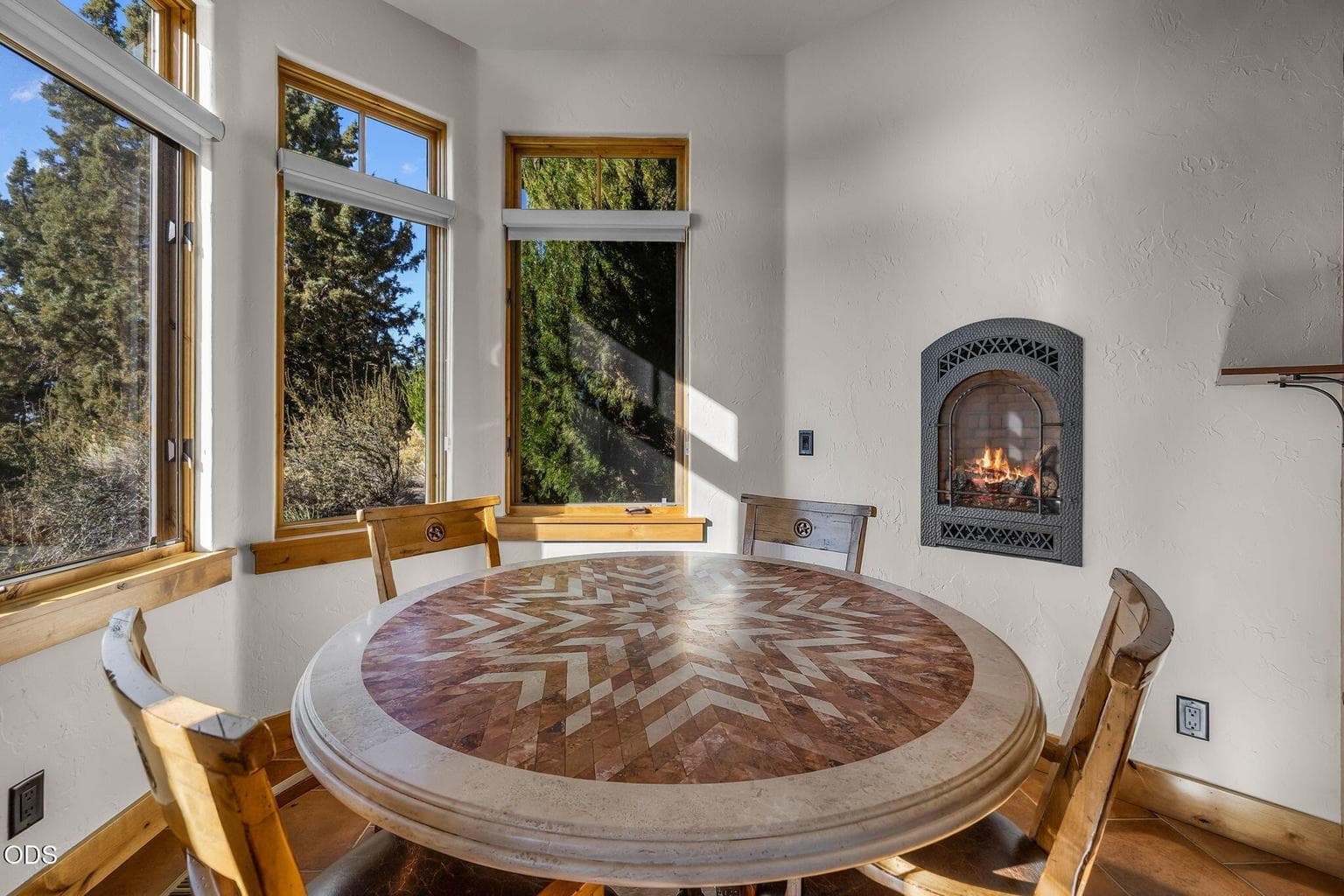 Framed by views of the Fazio golf course and Cascade Mountains, the breakfast nook features a gas wall fireplace that creates warmth and ambiance year-round