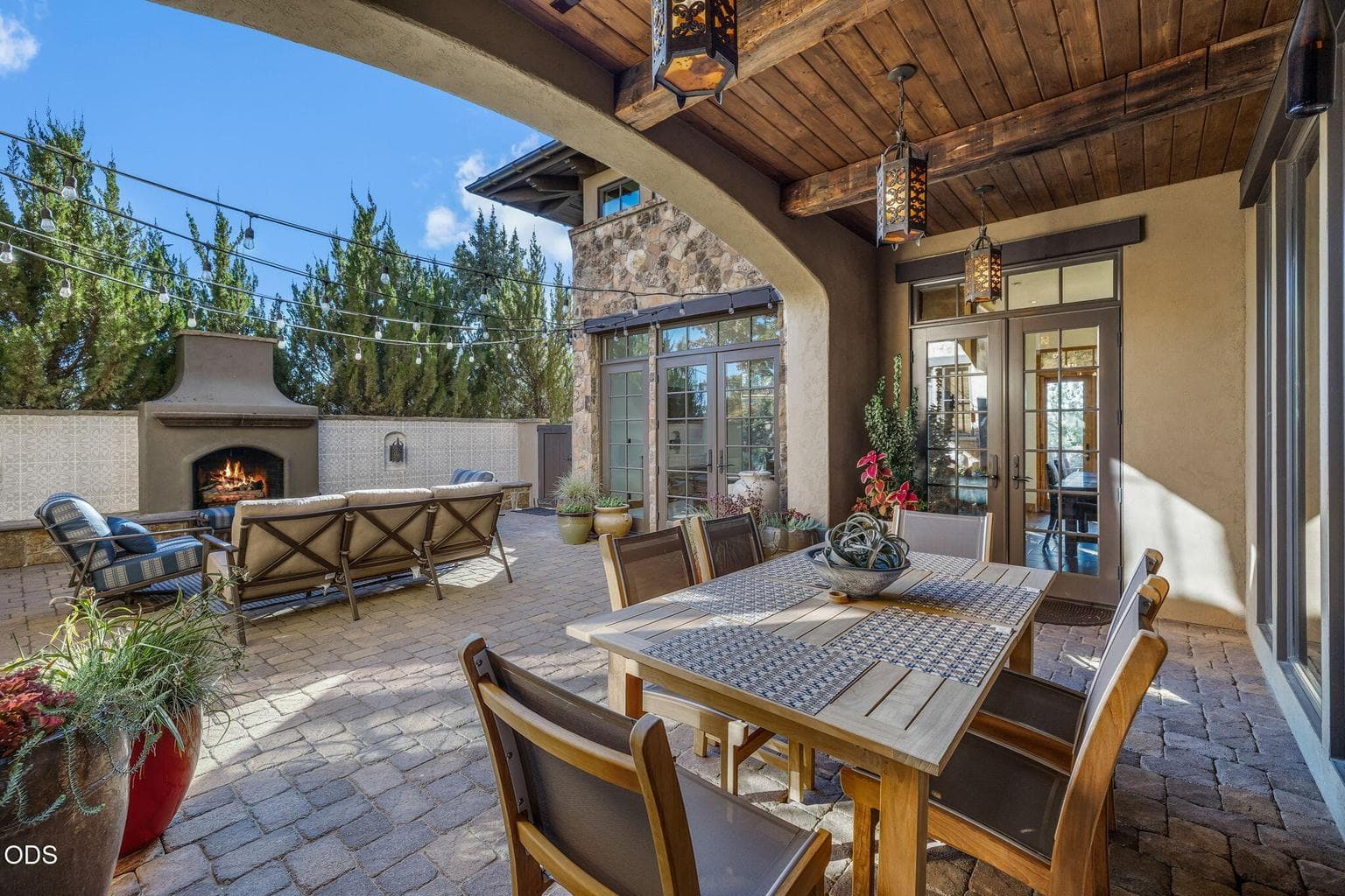 A serene interior courtyard sits at the center of the home, accessed through multiple French doors and enhanced by a large fireplace and tiled paver patio, creating a scenic and private retreat