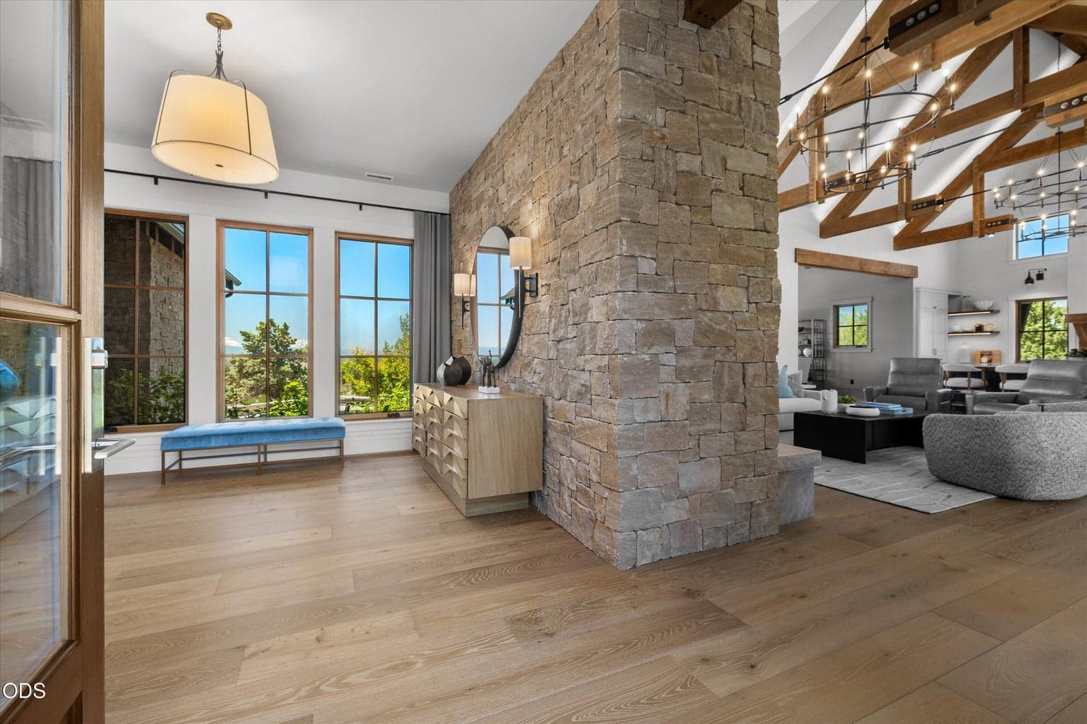 A warm entry to the home features an oversized foyer with statement stone, views of the Cascade mountains, connecting the primary bedroom and lockable guest suites to the living areas