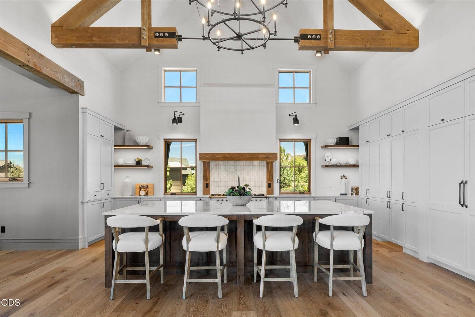 Living flows into a welcoming kitchen with high ceilings, natural light, oversized island and bar seating