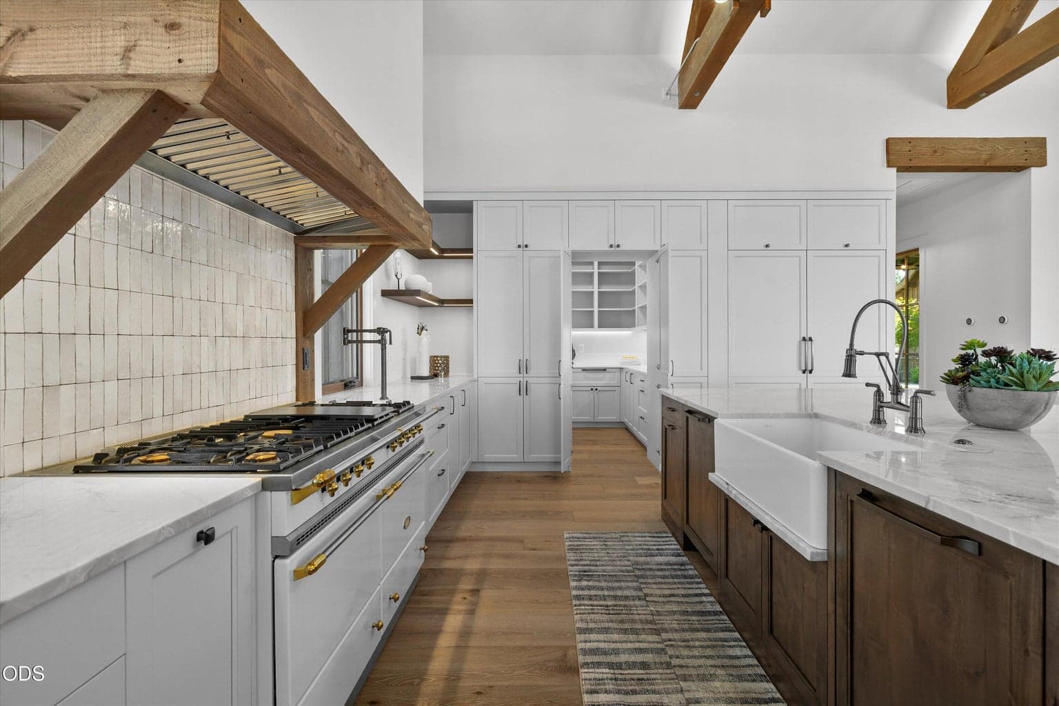 The chef’s kitchen is professional-grade with a 7-burner Lacanche range, a gas oven and an electric oven, Subzero/Wolf appliances, dual dishwashers, appliance garage, paneled built-ins, and a hidden butler’s pantry
