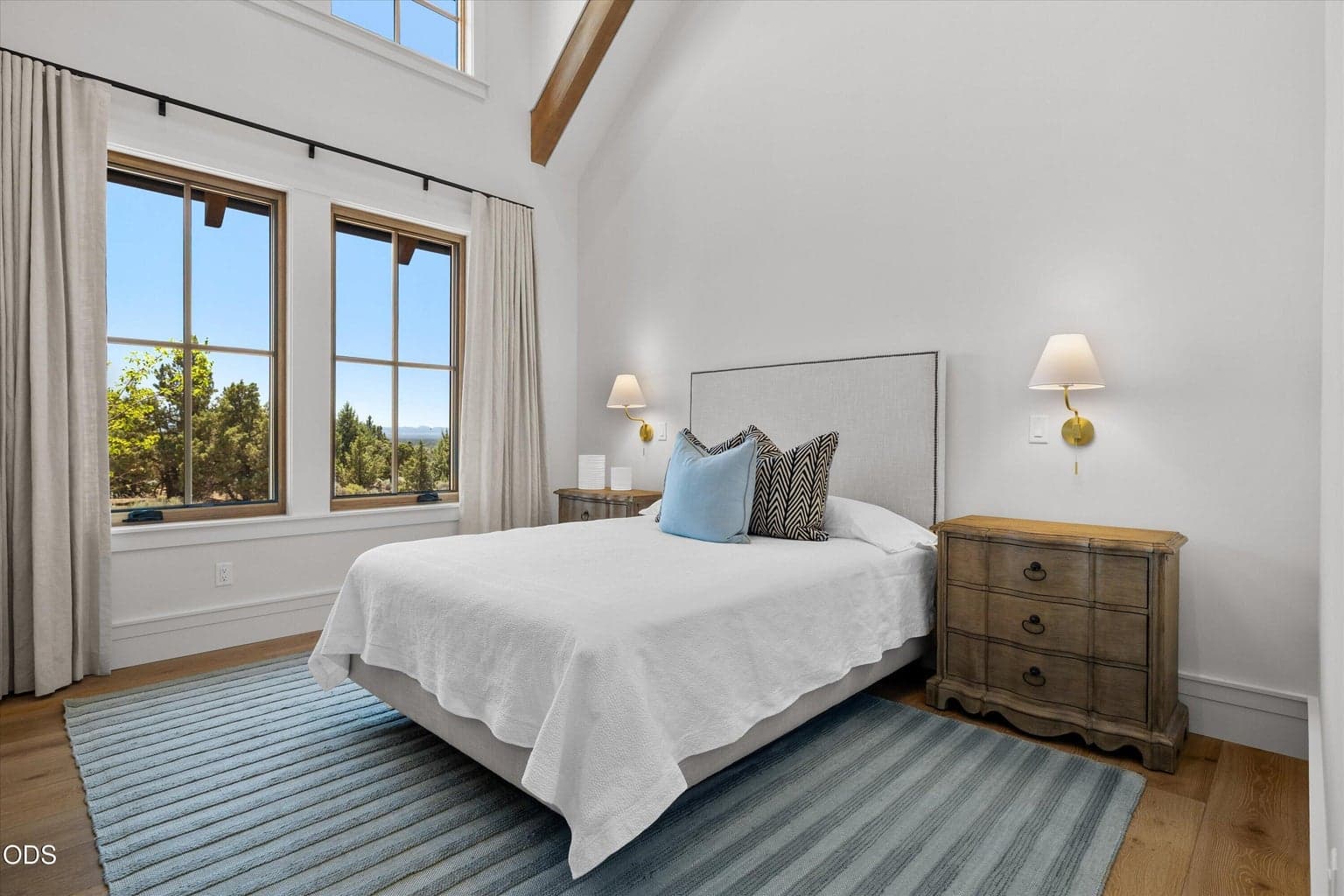 The second guest suite is framed by more high ceilings, beams, and natural light