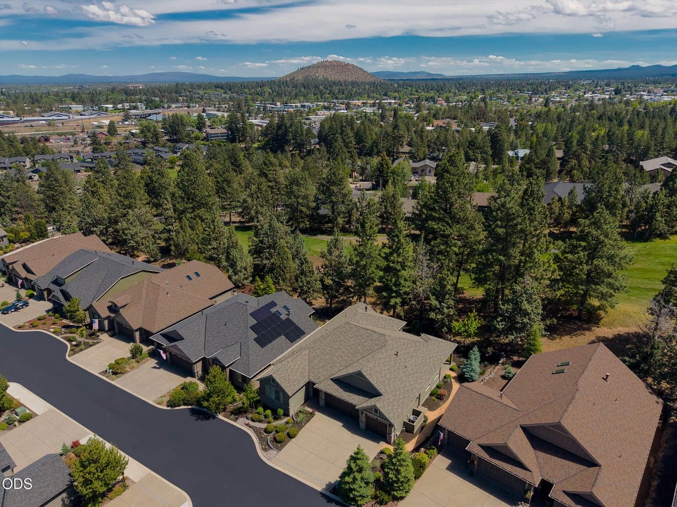 Neighborhood aerial overlooking golf course towards Pilot Butte.