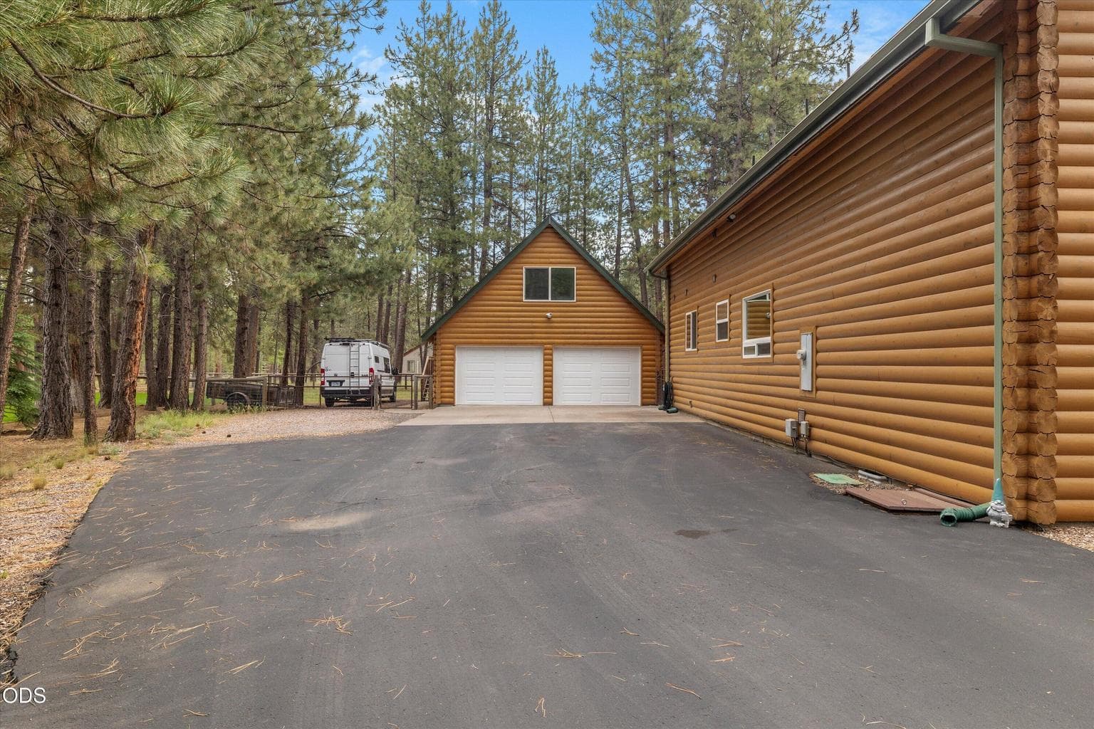 Driveway leads to gated parking area and an oversized two car garage.