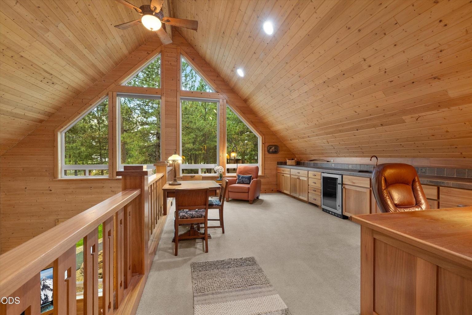 Custom built-in cabinets, beverage fridge and countertop line the loft wall making it a great place to lounge.