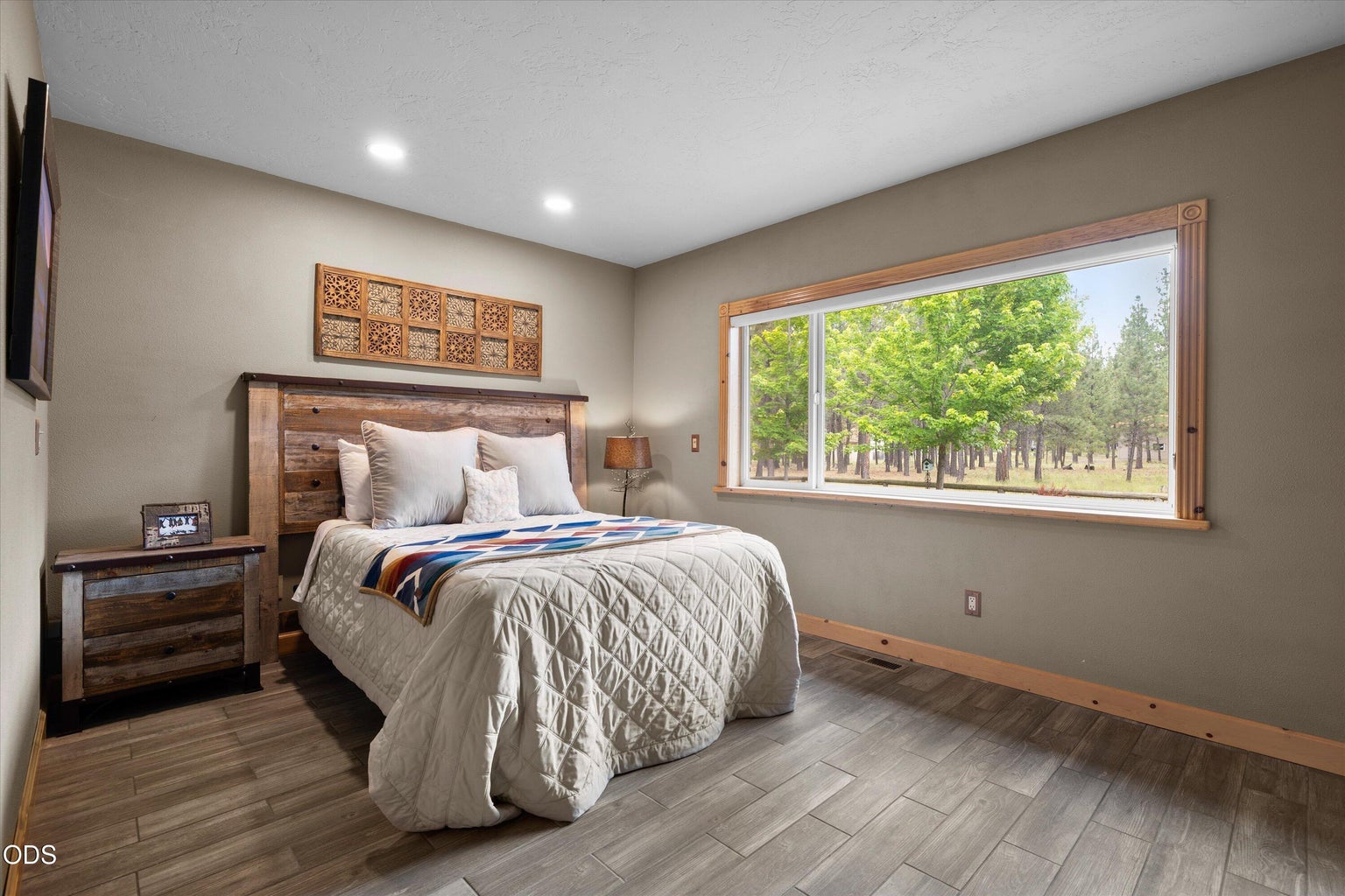 Primary suite on main level offers a view of the yard and plenty of room for furniture.