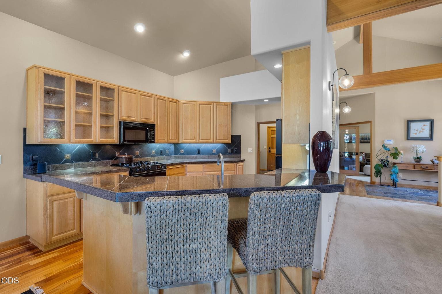 Well-designed kitchen with generous counter space, breakfast bar seating, warm cabinetry and connection to the main living areas.