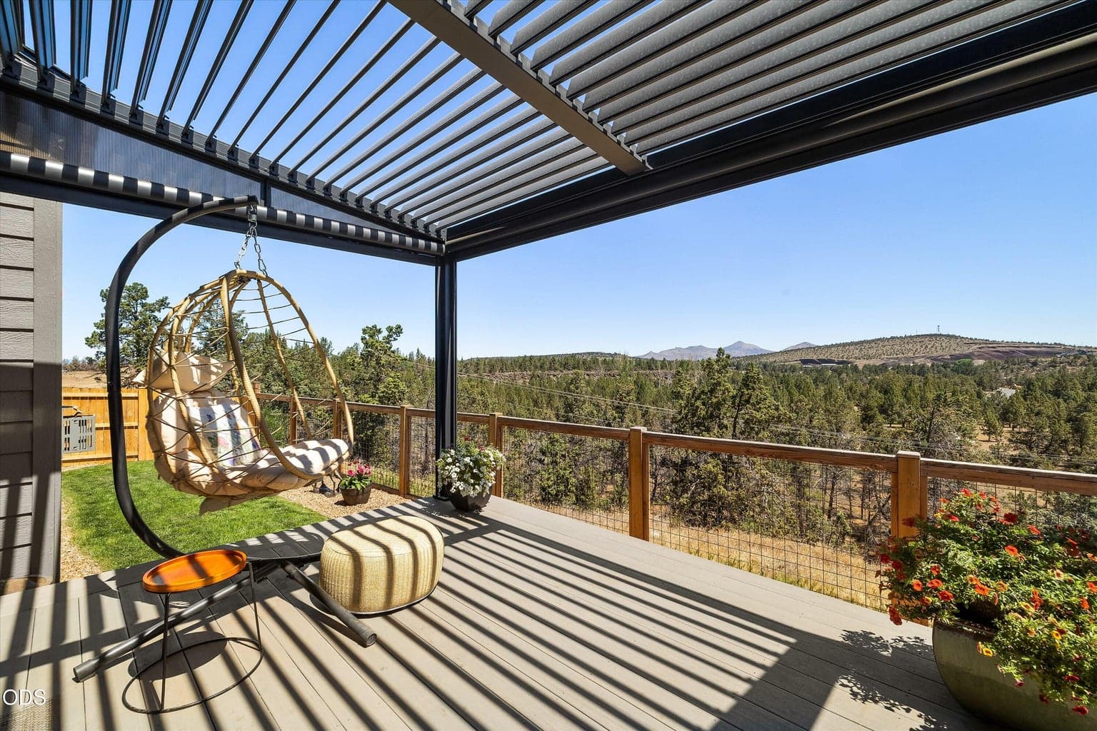 Aluminum shade pergola has louvered full closing top and retractable screens to enclose the deck.