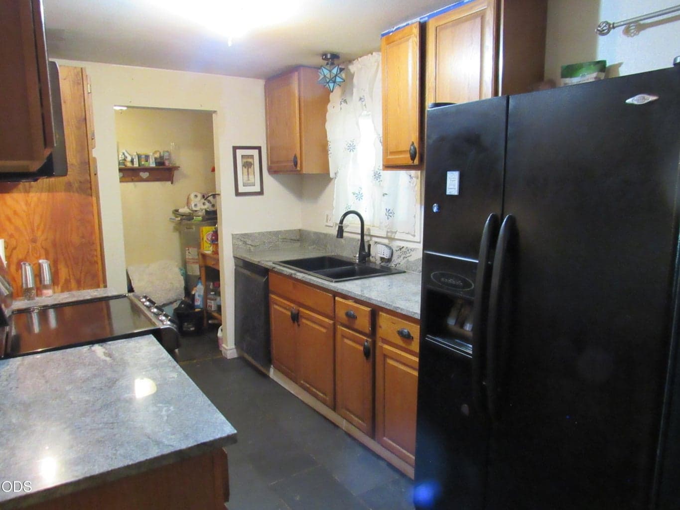 kitchen with new granite, sinks and cabinets. Opening is for washer and dryer, hot water tank