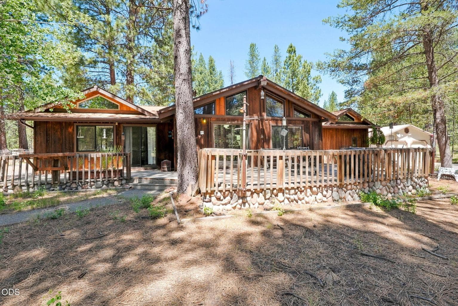 Back exterior home and deck as you follow driveway in