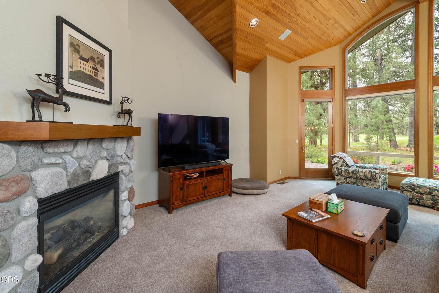 Livingroom Lennox gas fireplace with a rock fireplace and windows to the east, facing the fairway