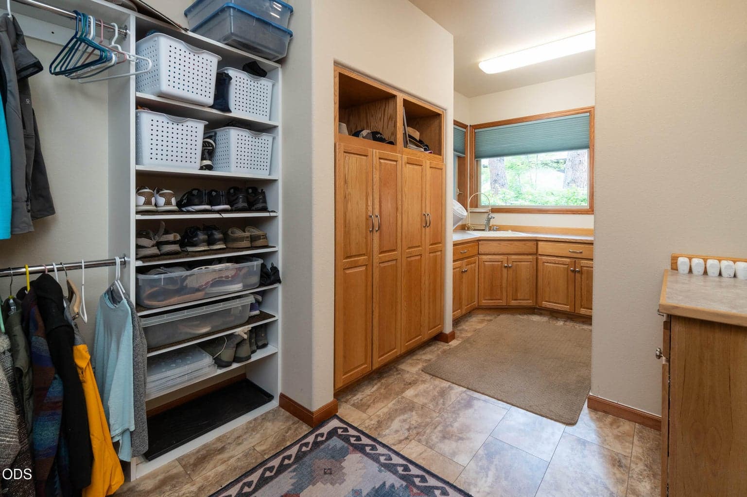 Utility room off the kitchen with storage built-ins and closet