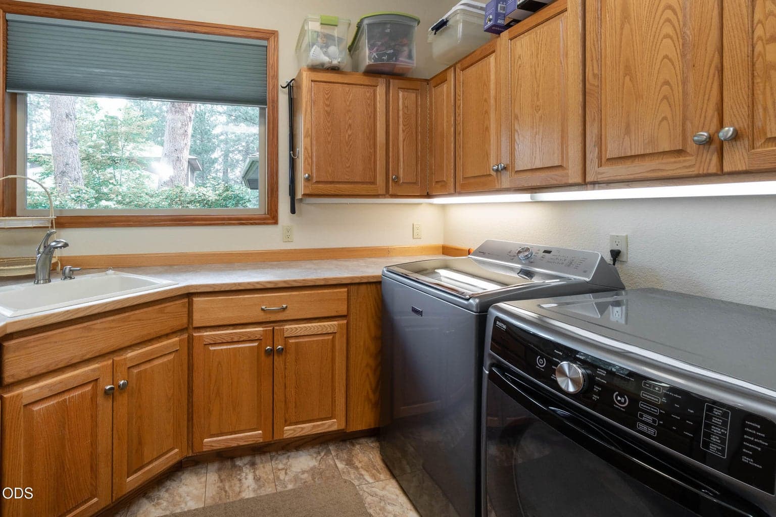Utility room with lots of cabinets, a deep sink and a Bravos XL Steam Washer and Maytag Commercial Dryer with a