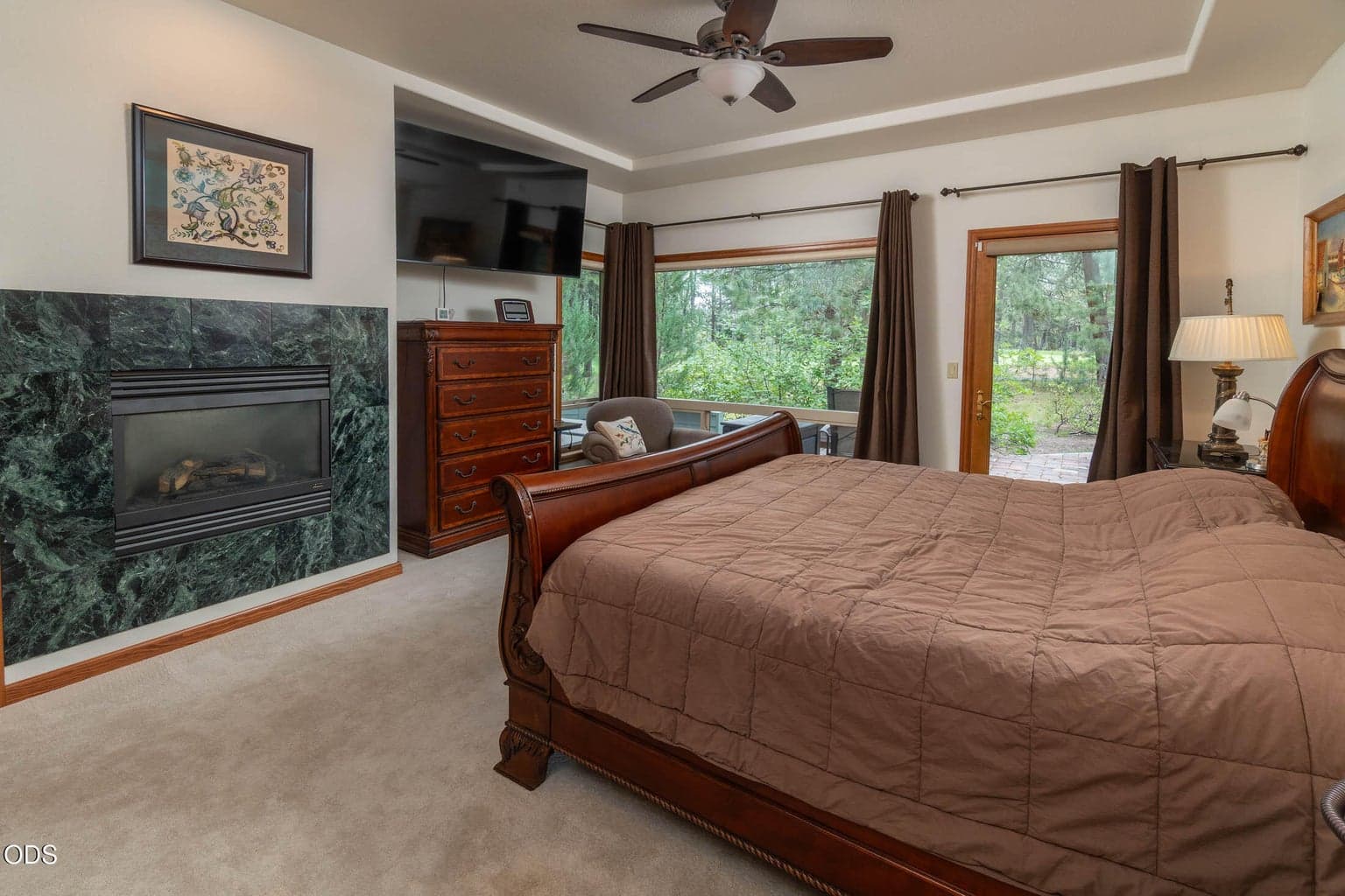 Primary bedroom with windows to the golf course and a gas Lennox fireplace
