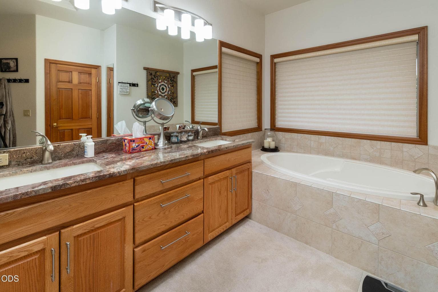 Primary bathroom with soaker tub and dual granite vanity