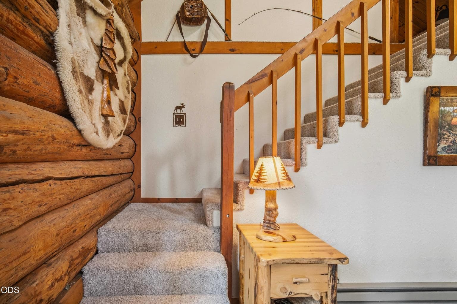The staircase rises from the main living area to the open upper loft, adding flexible sleeping and retreat space.