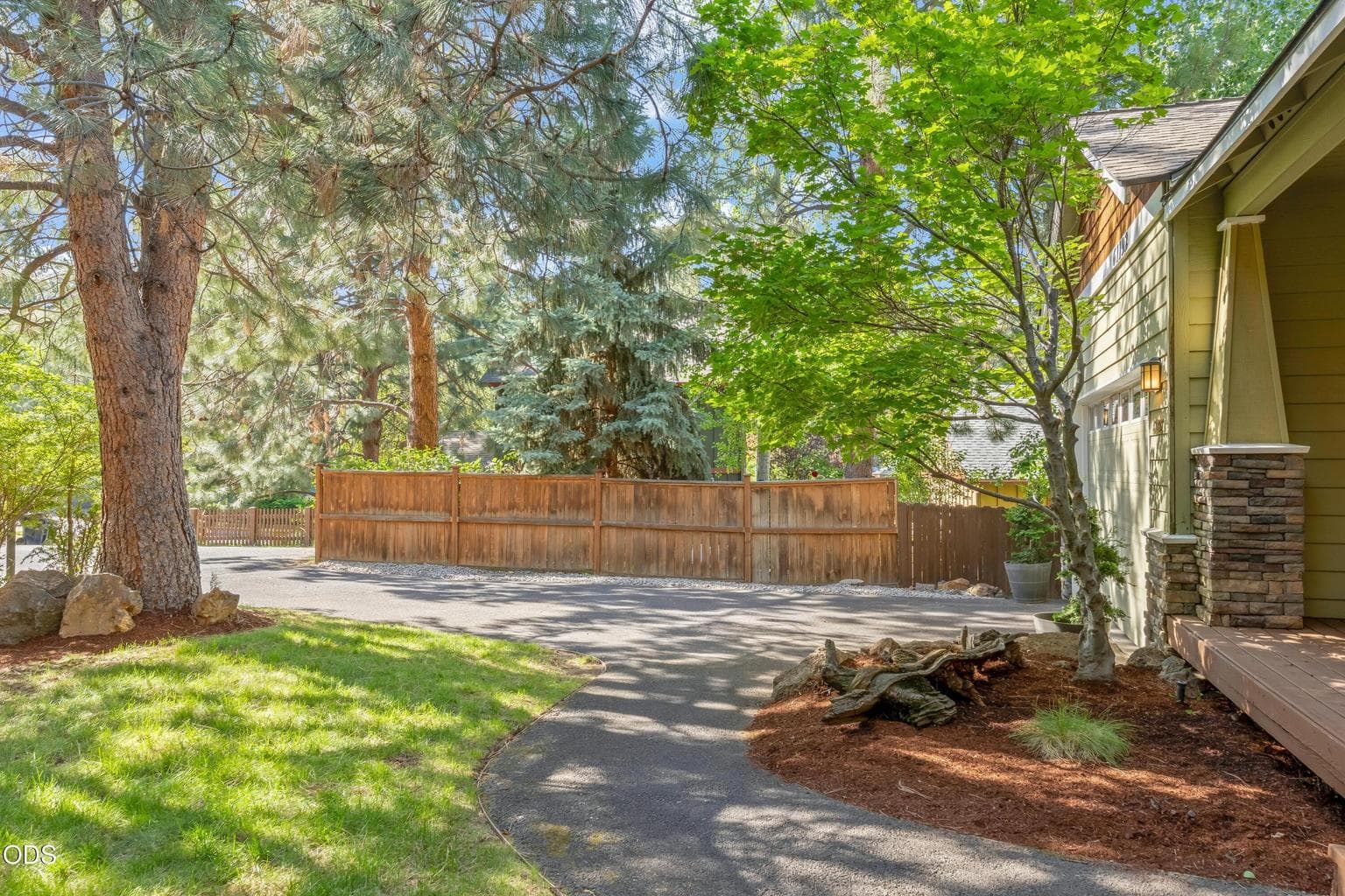The front yard opens to a cul-de-sac and has recently had new bark chips added to garden beds, crushed rock added to one side of the driveway and the trees limbed up