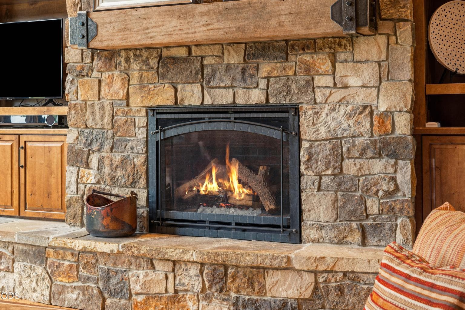 A floor-to-ceiling stone gas fireplace serves as the stunning focal point of the great room, creating a warm and inviting gathering space.