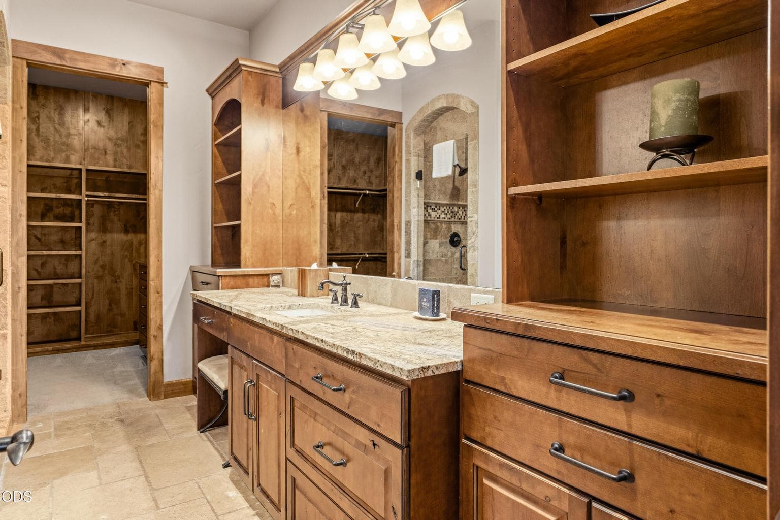 The luxurious primary bath features a granite vanity, custom cabinetry, tiled walk-in shower, and an oversized walk-in closet.
