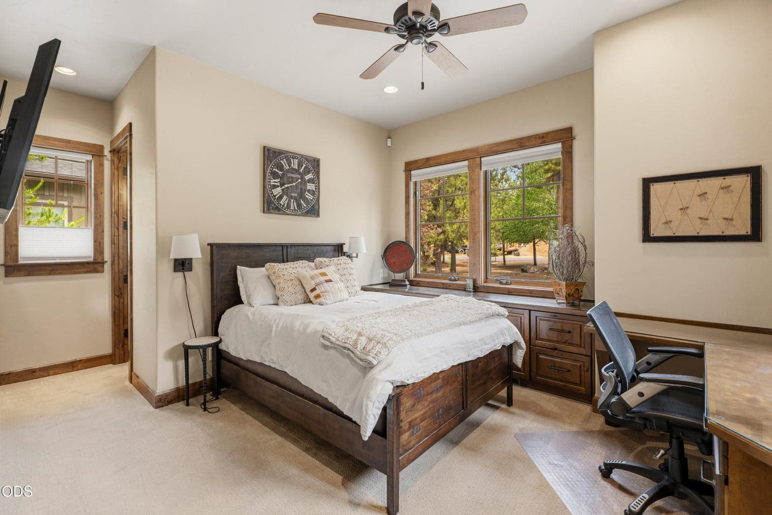 A spacious guest bedroom with custom built-ins offers the flexibility to serve as a comfortable home office or private retreat.
